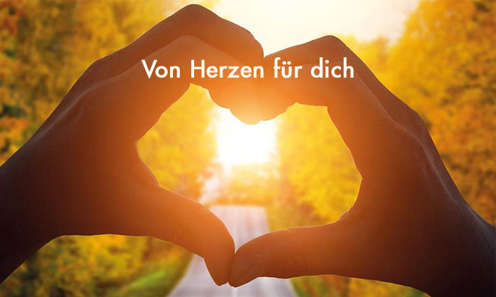 hellgelbe Schrift Von Herzen für dich - im Hintergrund Sonnenstrahlen scheinen durch zwei Hände, die ein Herz formen