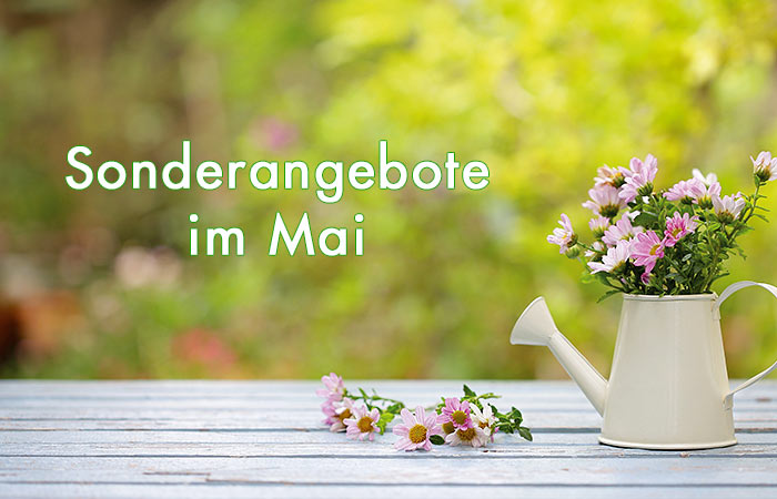weiße Schrift Sonderangebote im Mai - im Hintergrund eine Gießkanne mit Blumen