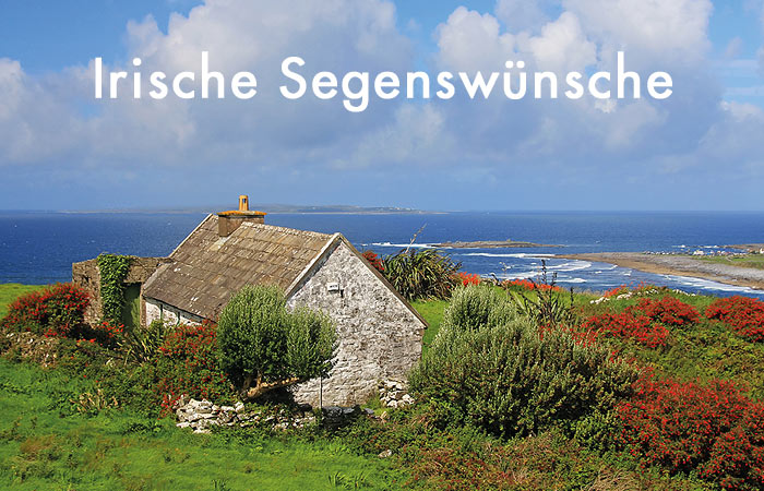 weiße Schrift Irische Segenswünsche - im Hintergrund ein altes Steinhaus an der Küste Irlands