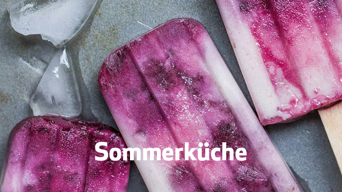 zur Themenseite Sommerküche weiße Schrift Sommerküche - im Hintergrund selbstgemachtes Heidelbeereis am Stiel