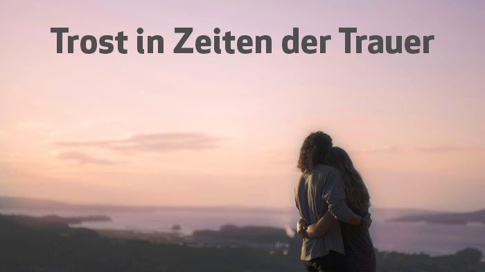 zur Themenseite Trost in Zeiten der Trauer dunkelgraue Schrift Trost in Zeiten der Trauer - im Hintergrund zwei Menschen, die sich umarmen